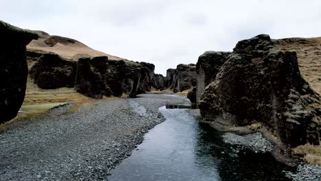 Drone-Volando-Río-Arriba-Cañón-Fjaðrárgljúfur-En-Islandia