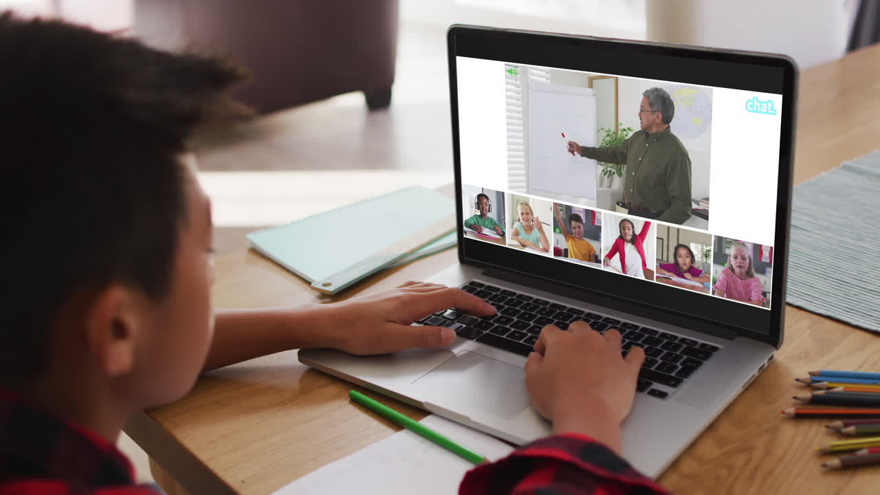 escolar que usa una computadora portátil para una lección en línea en casa, con un maestro y una clase diversos en la pantalla