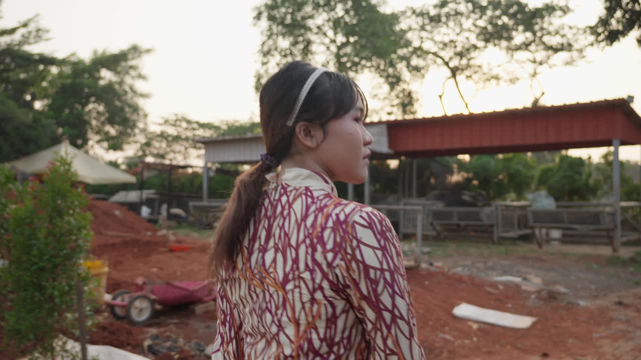 Indonesian girl walking through a lush farm landscape