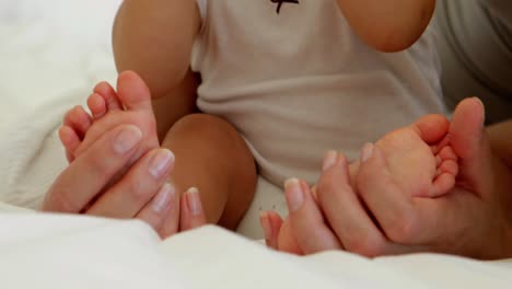 mother touching her baby daughters tiny toes