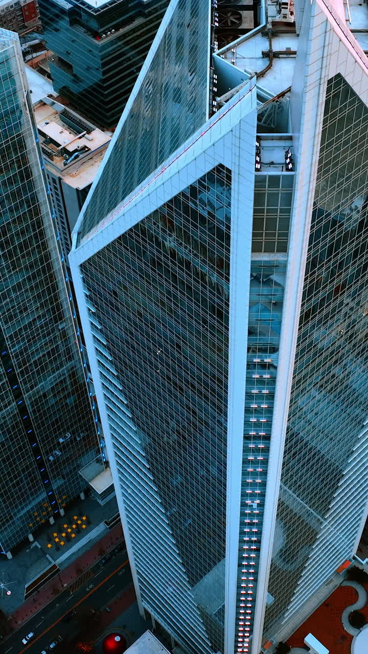 Alzándose sobre la cima puntiaguda de hermosos rascacielos con ventanas de espejo. Centro de Charlotte, Carolina del Norte, EE. UU. desde el aire. Vídeo vertical