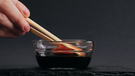 dipping salmon in soy sauce