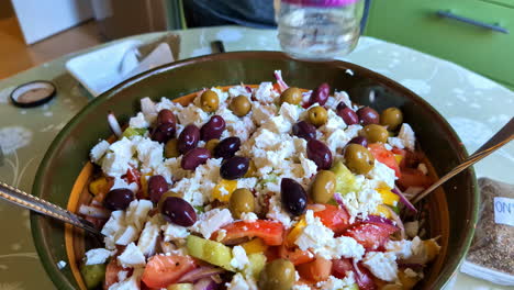 adding olives to a homemade greek salad recipe