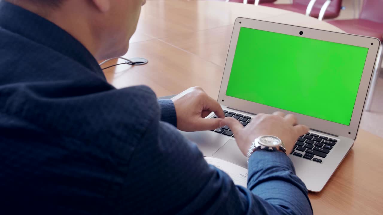 hombre de negocios trabajando en una computadora portátil con pantalla verde en