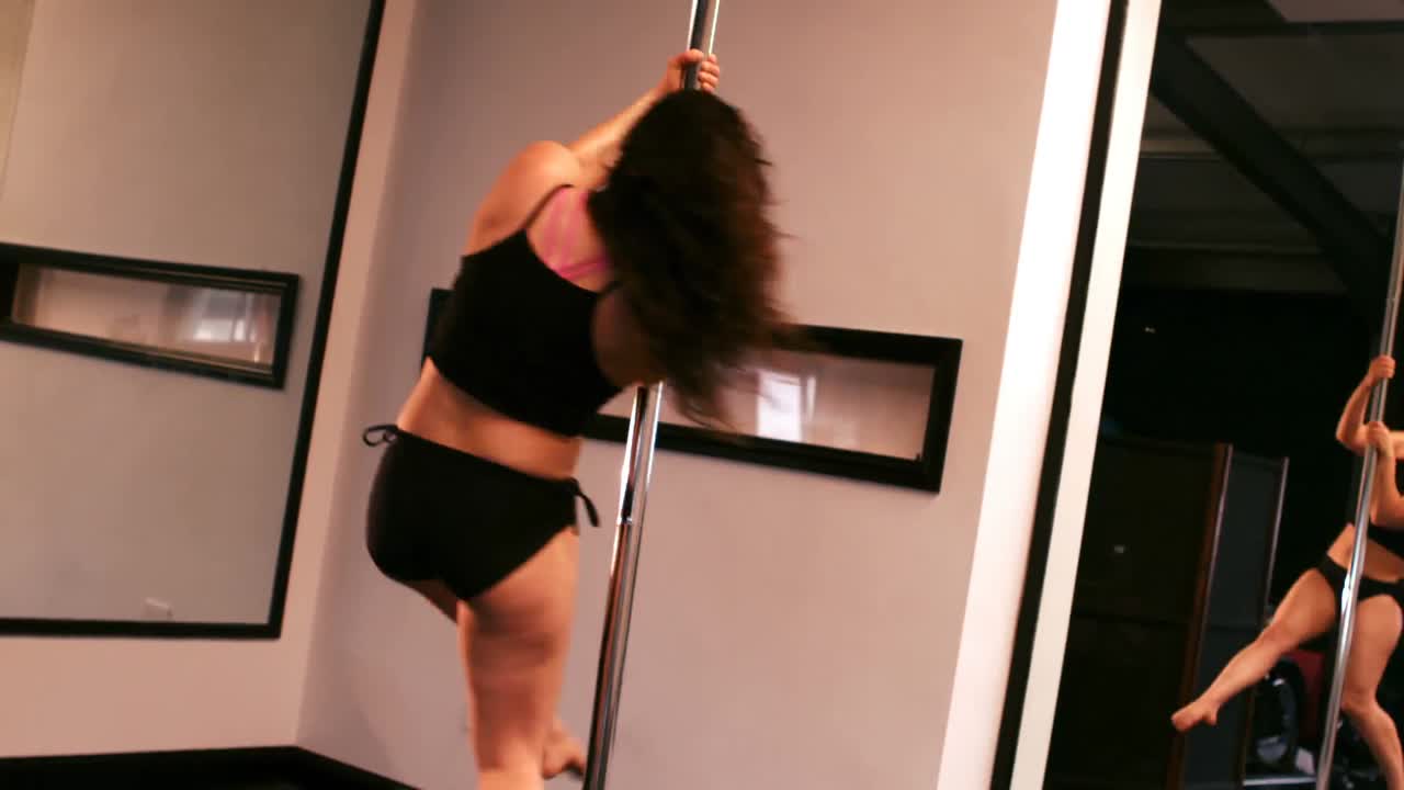Dançarina de pole dance praticando pole dance