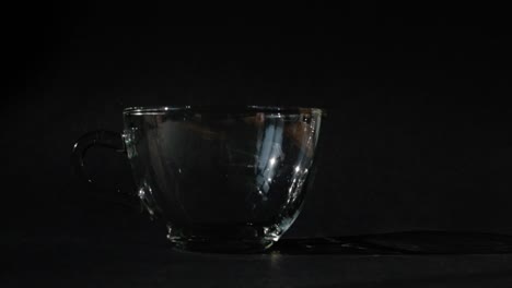 pouring hot coffee in a cup on a black background