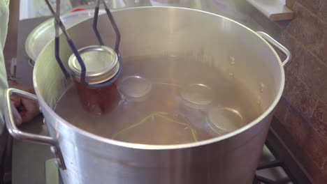 Man-Places-Jars-of-Jelly-in-Boiling-Water-to-Sterilize-and-Preserve