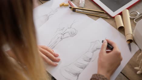 Crop-shot-of-dressmaker-drawing-sketches
