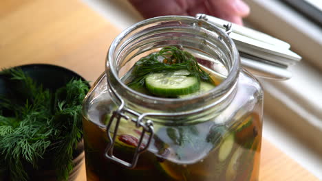 Opening-a-jar-of-fresh-pickles-and-eating-a-slice