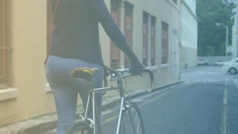 spots of light against low section of woman while walking with her bicycle on the street