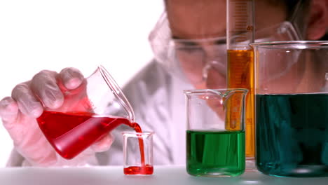 científico vertiendo líquido rojo en un vaso