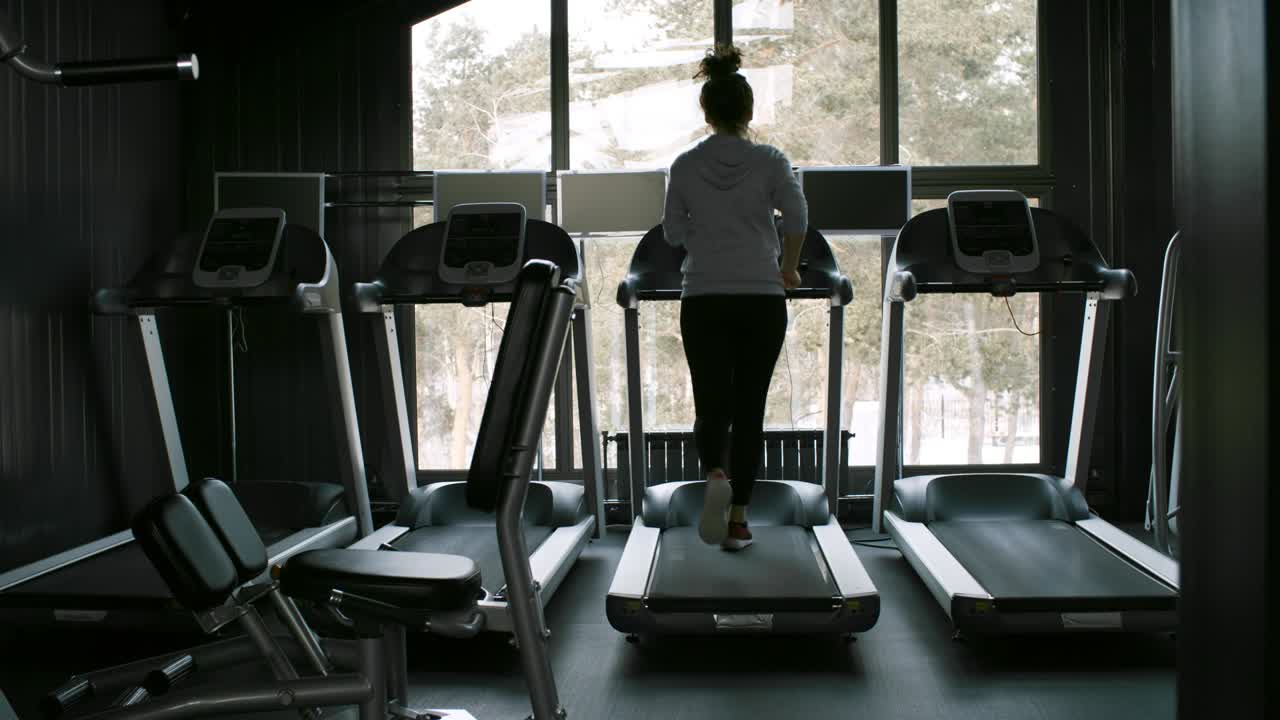 Woman Running on Treadmill in Empty Gym