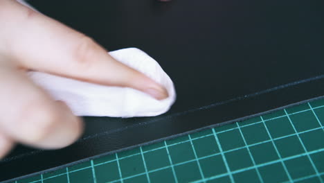 tailor hand wipes insoluble line on black leather cloth