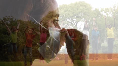 Composite-of-woman-wearing-face-mask-looking-out-of-window-and-children-playing-outdoors