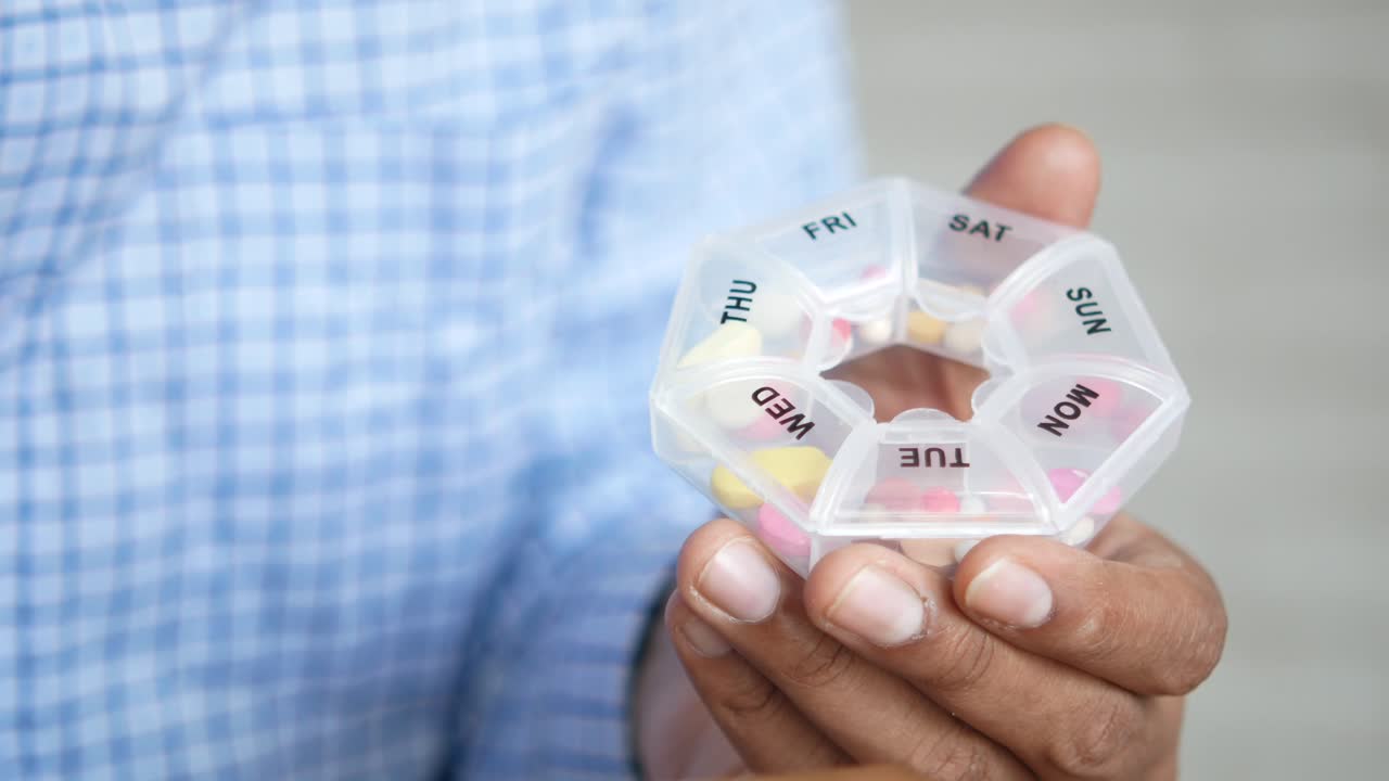 매일 복용하는 알약을 준비하는 사람