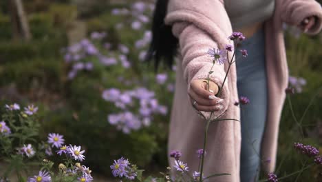 mujer con abrigo rosa lleva flores con ella