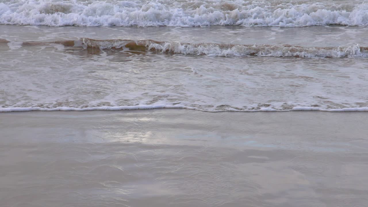 A serene view of waves softly crashing on a sandy beach along the Great Ocean Road, captured in natural lighting