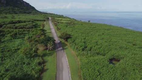 drone shot of car driving along banzai cliff, saipan, usa