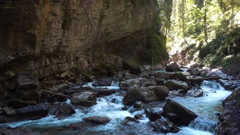 a blue, cold and clear mountain river flows through a gorge in the alps, water foams up