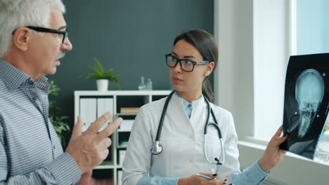 el médico discutiendo la radiografía con el paciente