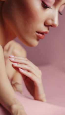 elegant manicure with red flowers on pink background