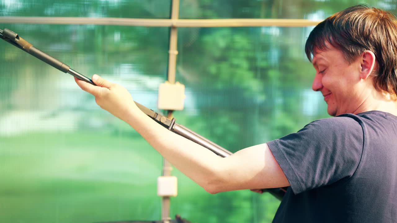 클로즈업 젊은이들이 공기총으로 사격장에서 총을  ⁇ 습니다. 그들 중 한 명이 총을 깨뜨렸습니다.