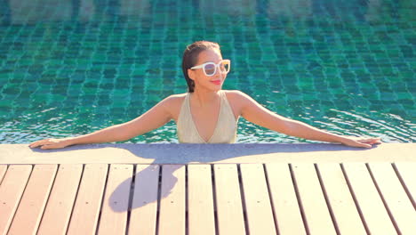 Joven-Asiática-Con-Gafas-De-Sol-Relajándose-En-La-Piscina