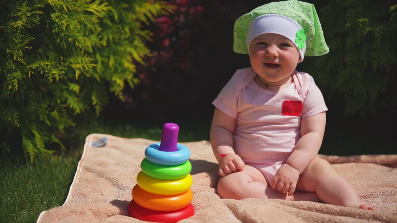 Baby girl playing with ring stack toy outdoors