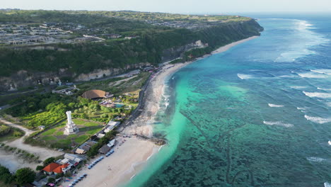 shallow azure ocean wraps around uluwatu peninsula in bali near popular vacation spot pantai pandawa