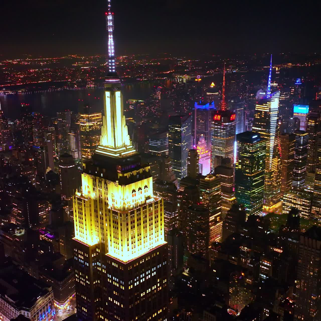 Fascinating Empire State building with lighted top at night. Striking scenery of New York skyscrapers at the backdrop of black skies