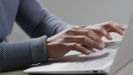 video of biracial businessman using laptop on grey background