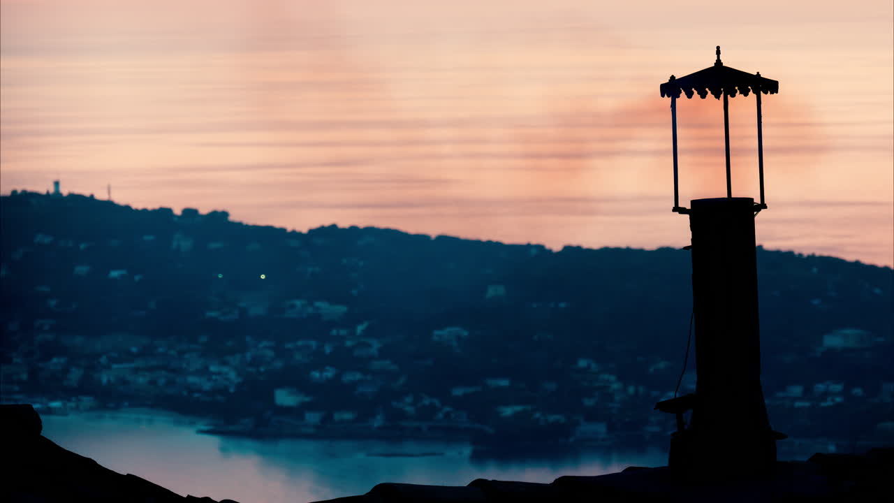 Aerial view a lighthouse with the Eze seaside commune in the Alpes-Maritimes at sunset on the background