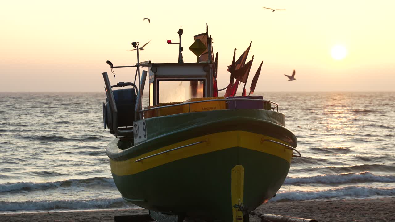 Piccola barca da pesca su spiaggia sabbiosa all'ora d'oro, con gabbiani che volano intorno