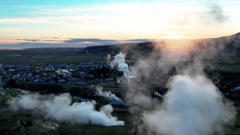 aguas termales y la ciudad de hveragerdi en el sur de islandia durante la puesta de sol - toma aérea de dron