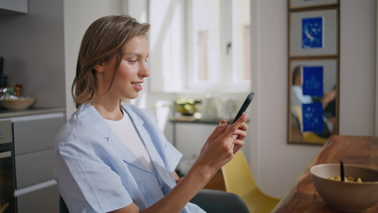 Smiling woman using mobile phone during breakfast closeup. Happy student resting