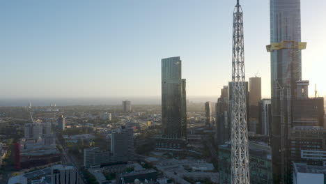 aerial decent revealing melbourne art spire and city apartment buildings on stunning dusk evening