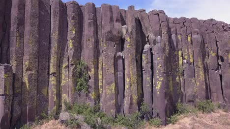 Dolly-shot-ascends-tall-rugged-volcanic-basalt-columns,-WA-Scablands