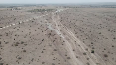 vista aérea de un camión conduciendo por el polvoriento desierto