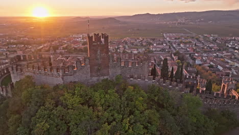 scaliger castle overlooks the historic town between the medieval walls in soave, italy during sunset