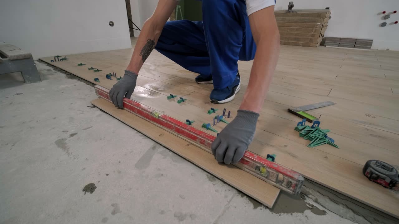 Installing ceramic floor tiles - measuring and cutting the pieces. Construction, renovation, repair apartment. Cuts tile. Tile cutting