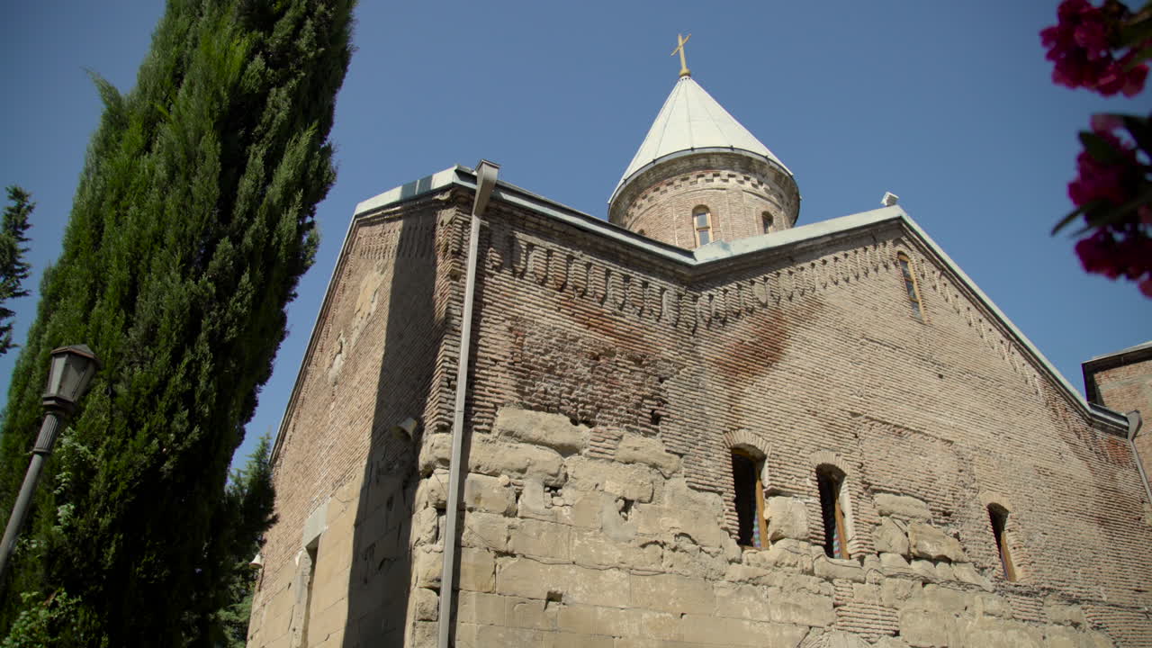una vista de ángulo bajo sobre los árboles de la iglesia ortodoxa georgiana del siglo xii en el monasterio lurji, o "iglesia azul", en tbilisi, georgia