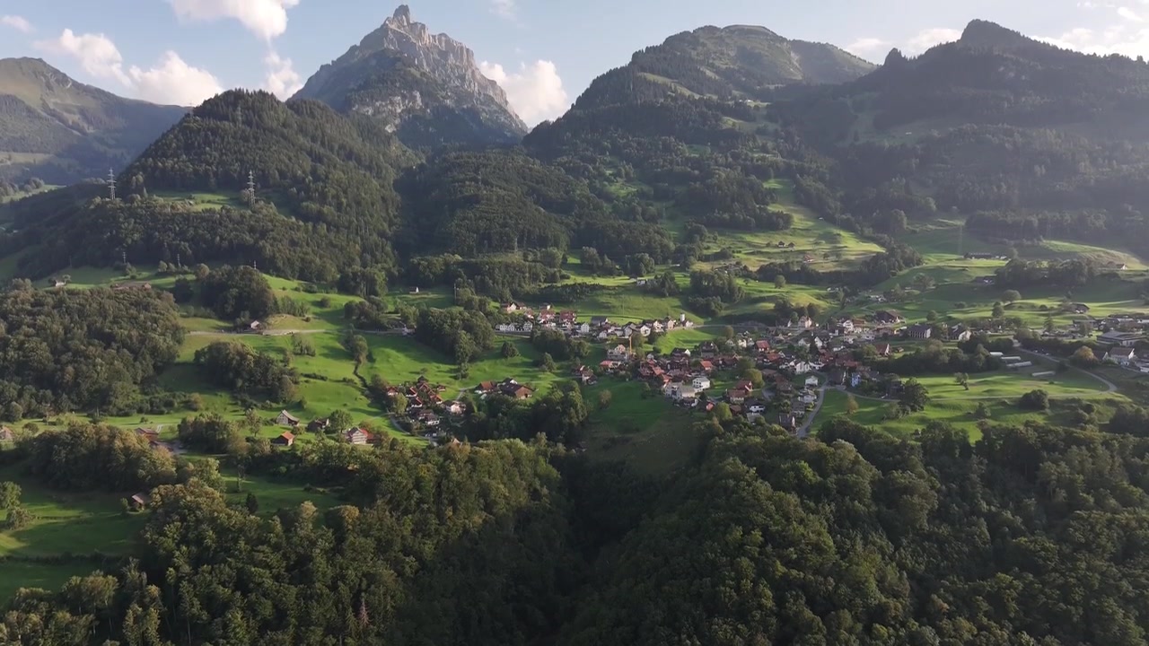 Aerial View Of Road Along The Walensee Lake And Filzbach Town Houses On The Mountain In Glarus Nord, Switzerland. - tilt up shot