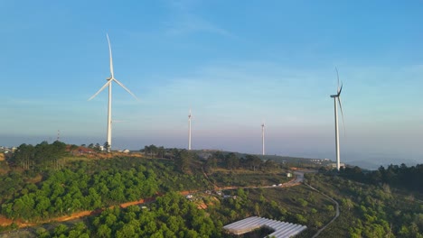 wind turbines spin on a hill in the morning of a brilliant sunrise in da lat - vietnam