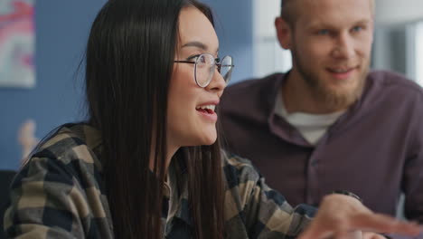 Eyeglasses-girl-gesturing-at-video-call-remote-workplace.-Students-brainstorming