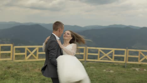 una hermosa pareja de bodas celebrando su matrimonio con un beso en las montañas