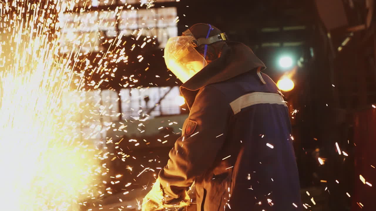 Worker Welding Metal in Factory