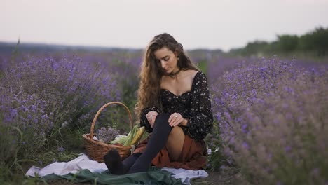 Sensual-woman-on-lavender-field,-putting-on-black-tights,-slow-motion