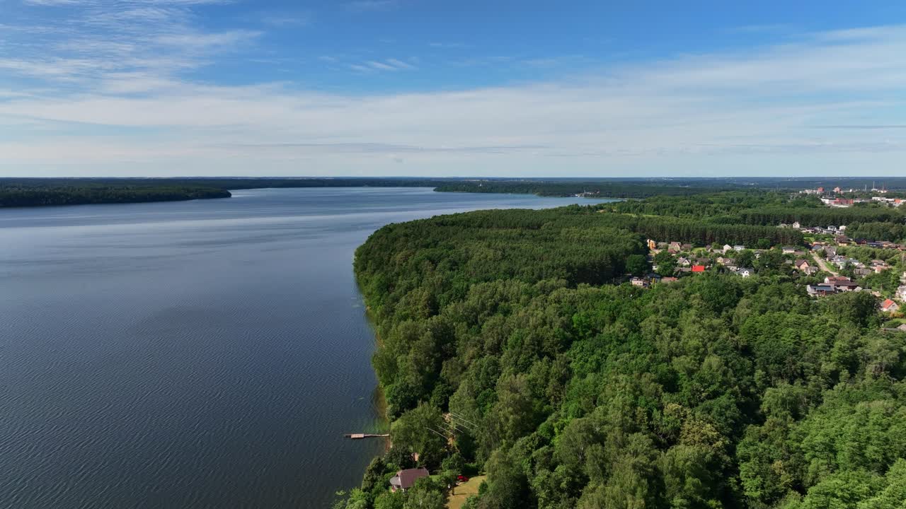 Vista panoramica, grande lago, rive coperte di alberi verdi, giornata estiva soleggiata, natura dei paesi baltici.