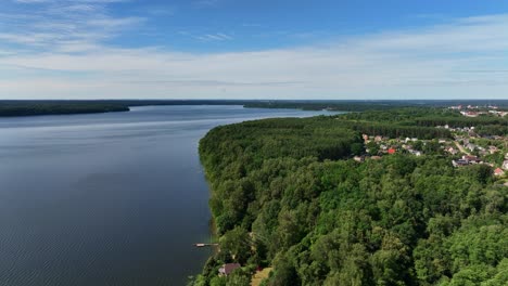 Panoramic-view,-large-lake,-shores-covered-with-green-trees,-sunny-summer-day,-nature-of-Baltic-countries