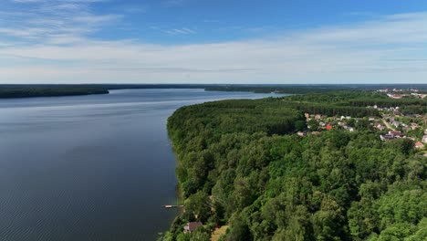 panoramic view, large lake, shores covered with green trees, sunny summer day, nature of baltic countries